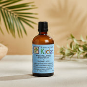 Tanamera Kidz Baby Full Body Massage Oil in a 100ml amber glass bottle with a black cap and a light blue label.
